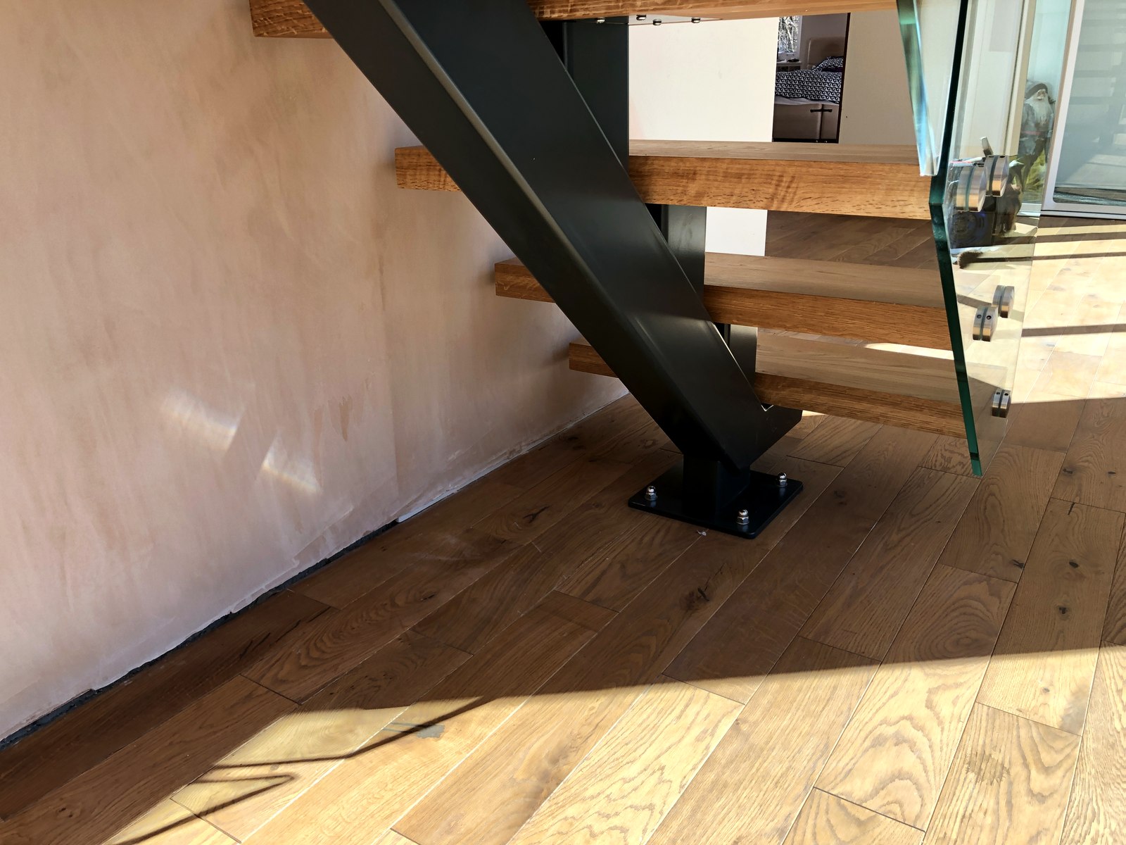 Anthracite grey (RAL 7016) powder-coated steel box-section spine carrying oak treads, underside detail, Surrey