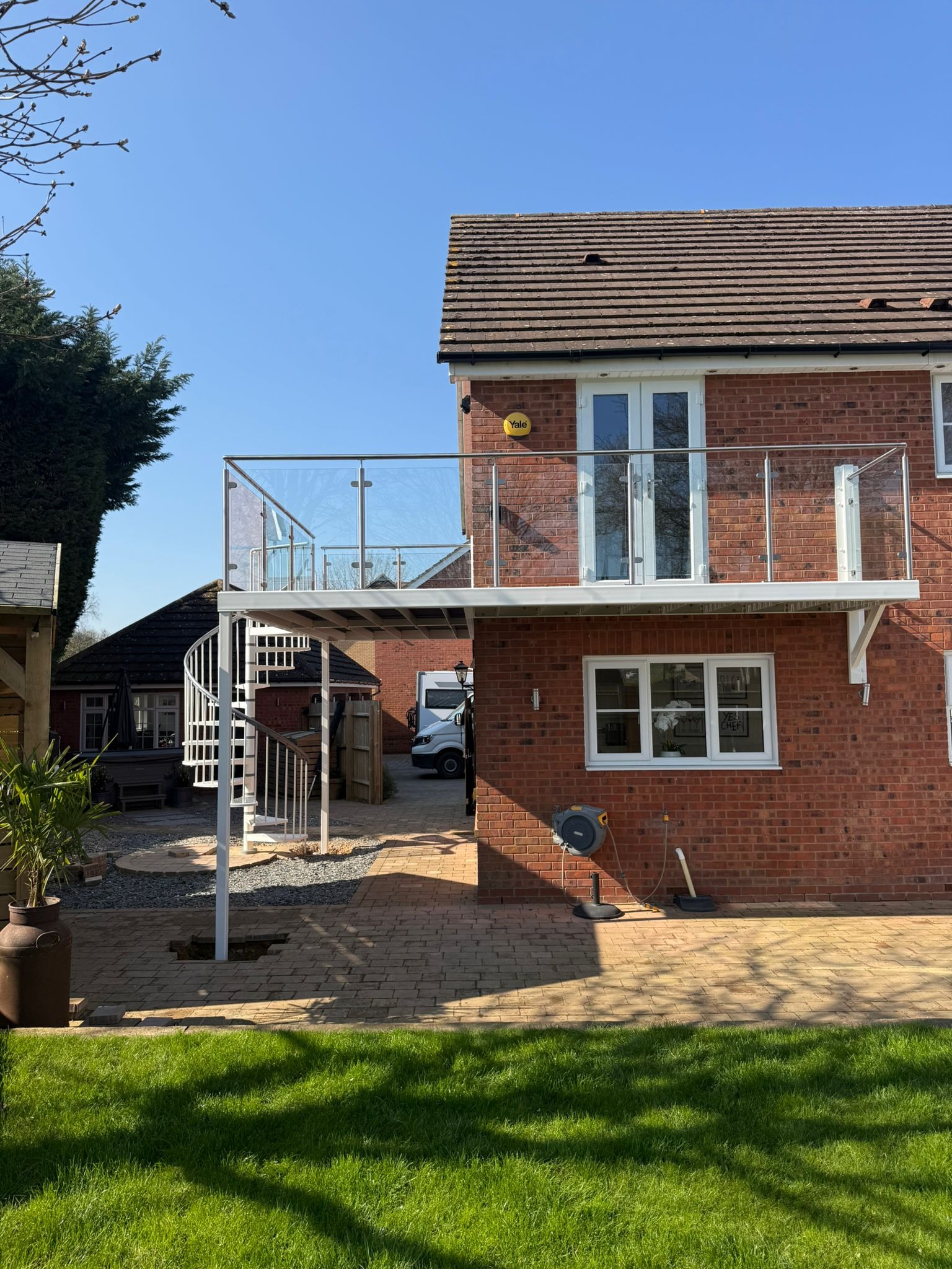 Overhead view of spiral staircase connecting to composite decking balcony with stainless steel glass balustrade, Northampton