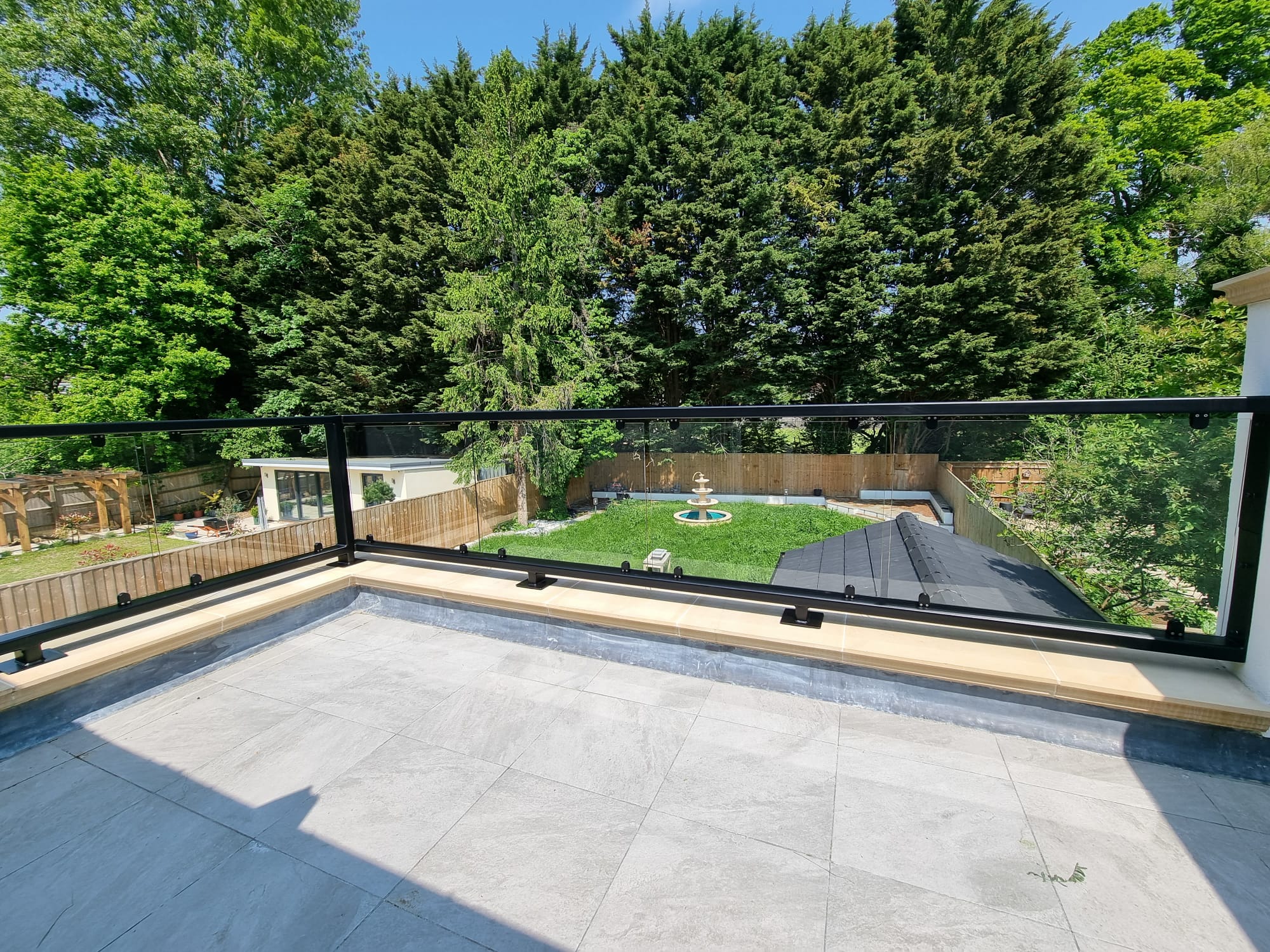 Powdercoated steel and glass balustrade installed to parapet wall on first floor terrace, Oxfordshire