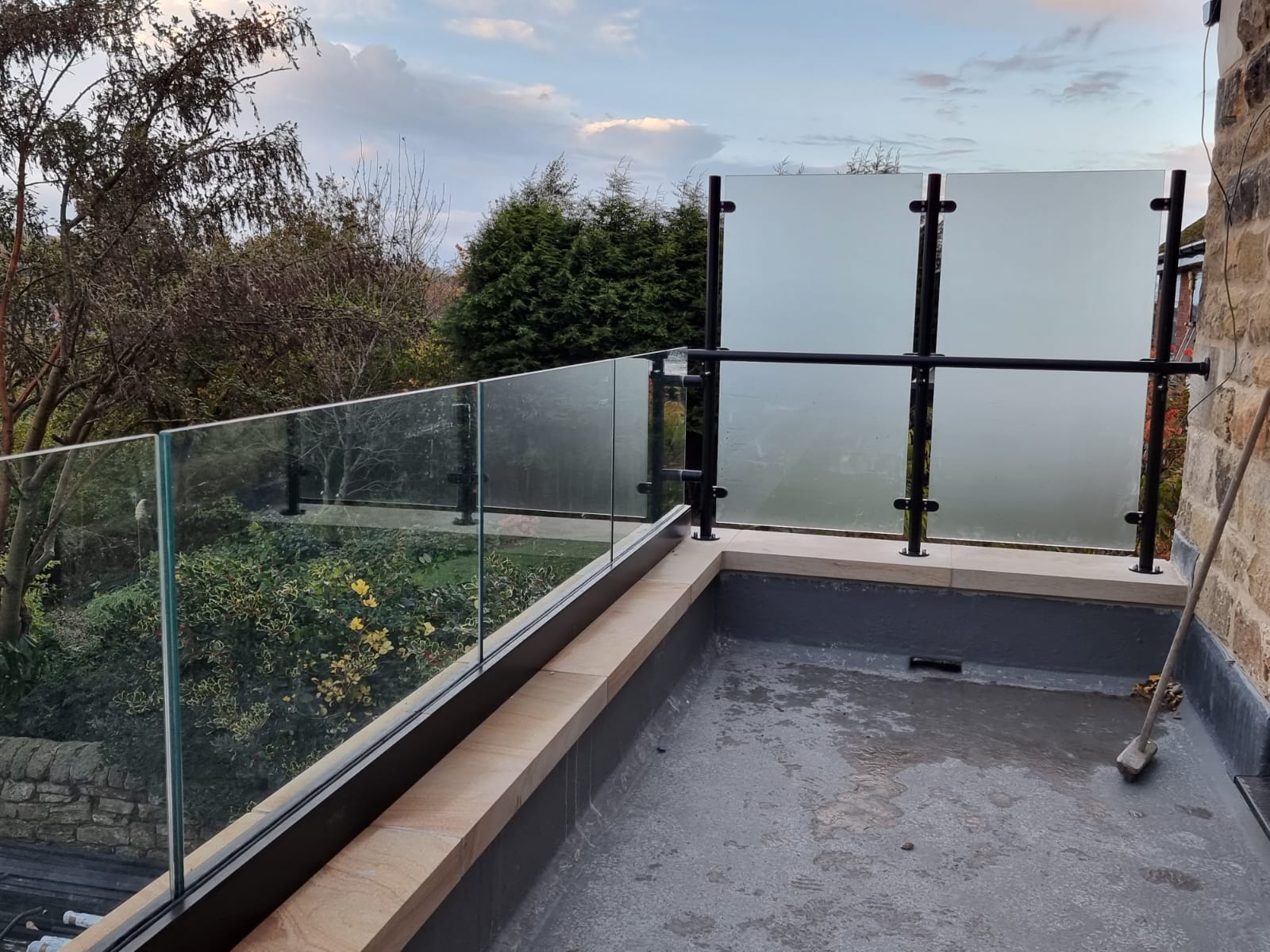 Large residential installation of frameless glass balustrades with black base channels and frosted privacy screens in Mosborough, Sheffield.