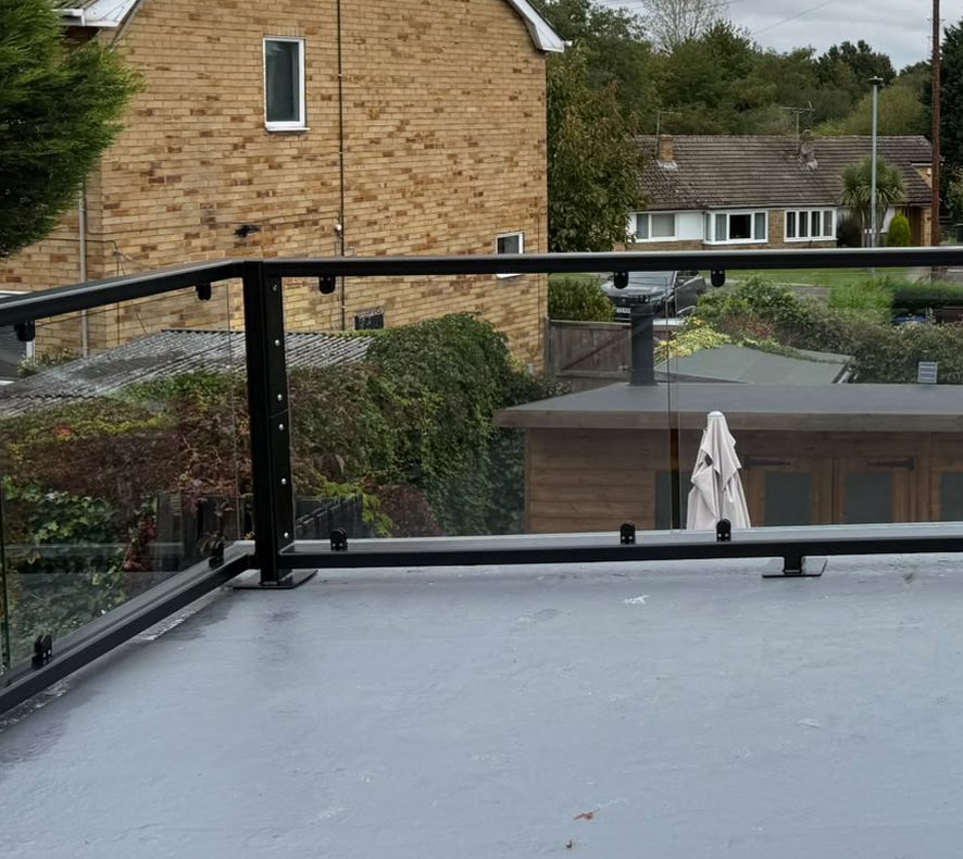 Corner post and bolted flat bar fixing plate on a flat roof glass balustrade, Barnsley