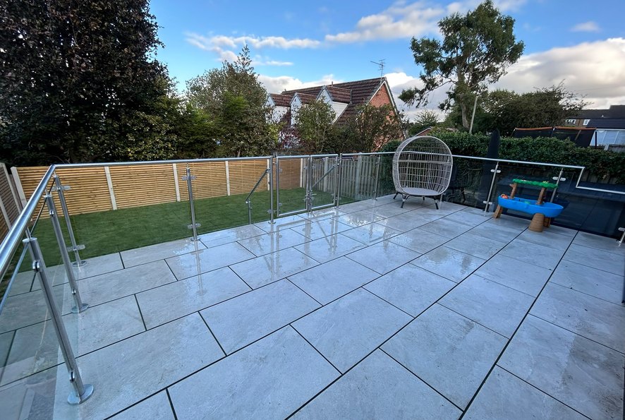 Glass balustrade return run along the side of a porcelain paved raised patio in South Yorkshire