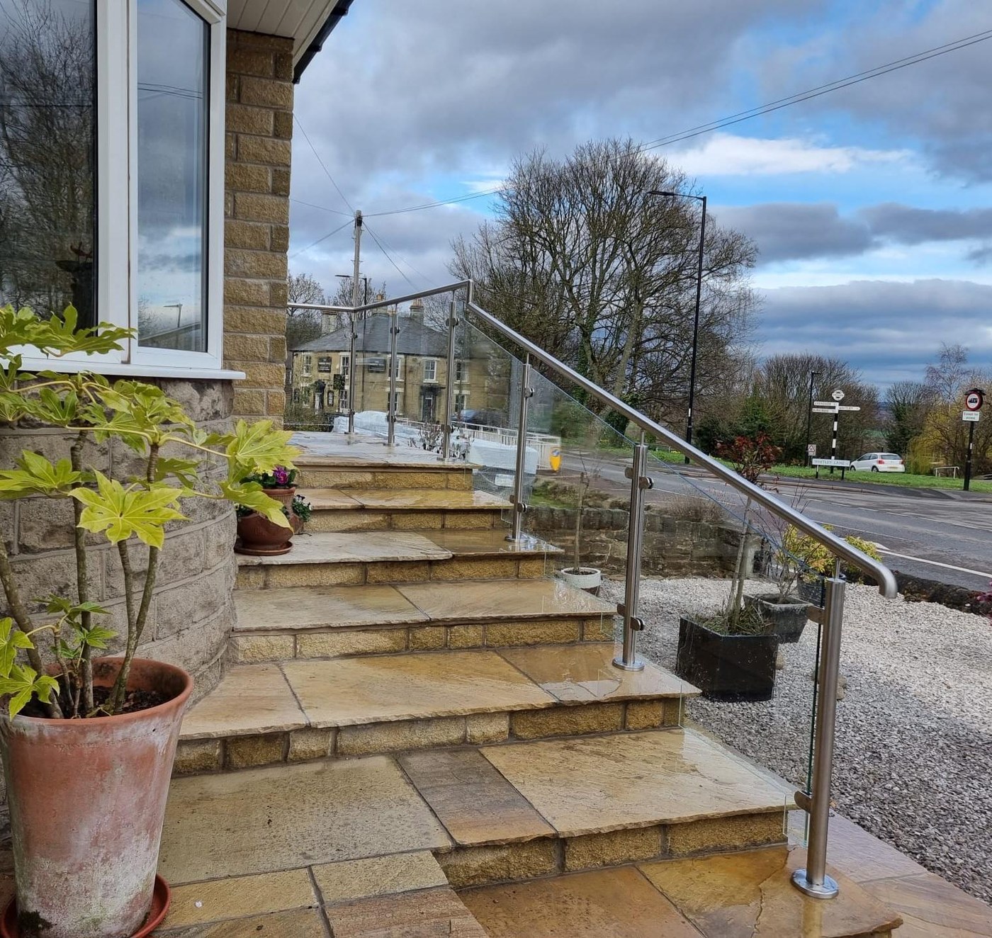 Satin brushed stainless steel and glass balustrade to stone garden steps at a house in Grenoside Sheffield