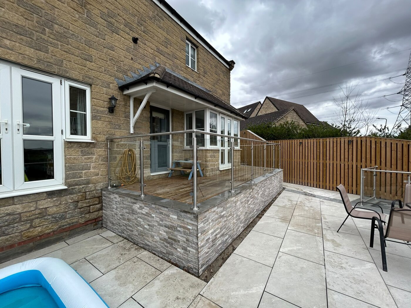 Satin brushed 316 stainless steel posts and handrail with clear toughened glass on a raised terrace, Rotherham