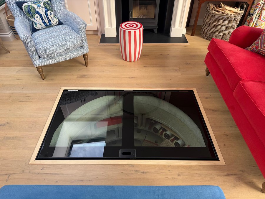 Walk on glass cellar door closed flush with the oak floor of a living room seen from above