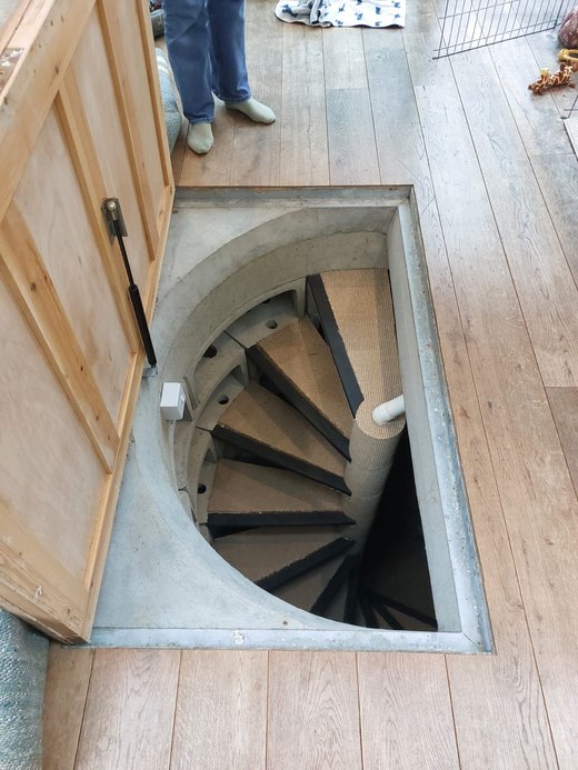 Rectangular floor opening over a round concrete cellar well and spiral staircase