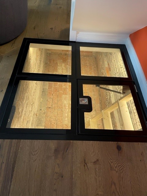 Walk-on glass floor over a cellar with an opening hatch section