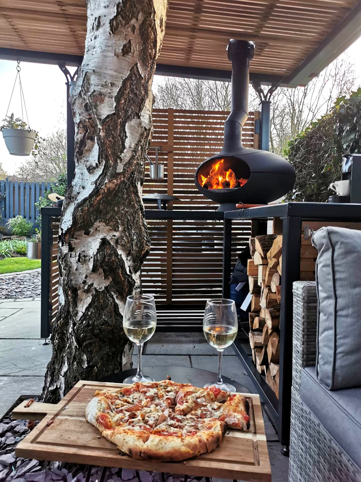 Integrated cast-iron pizza oven with chimney through the pergola roof, Sheffield