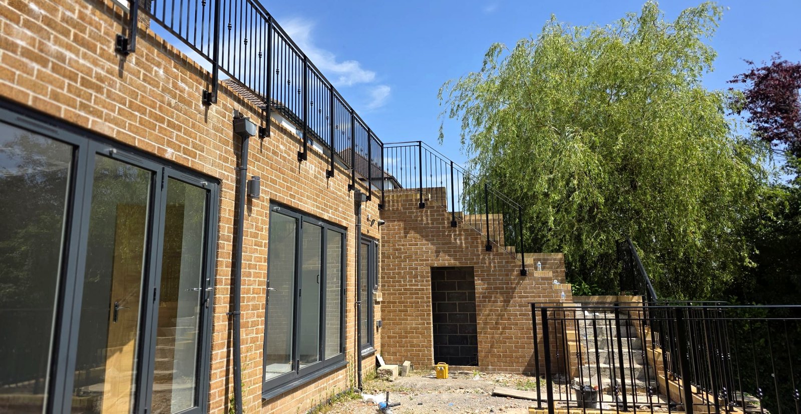 Powder-coated black balustrade railings to a terrace beside large windows, Sheffield S11