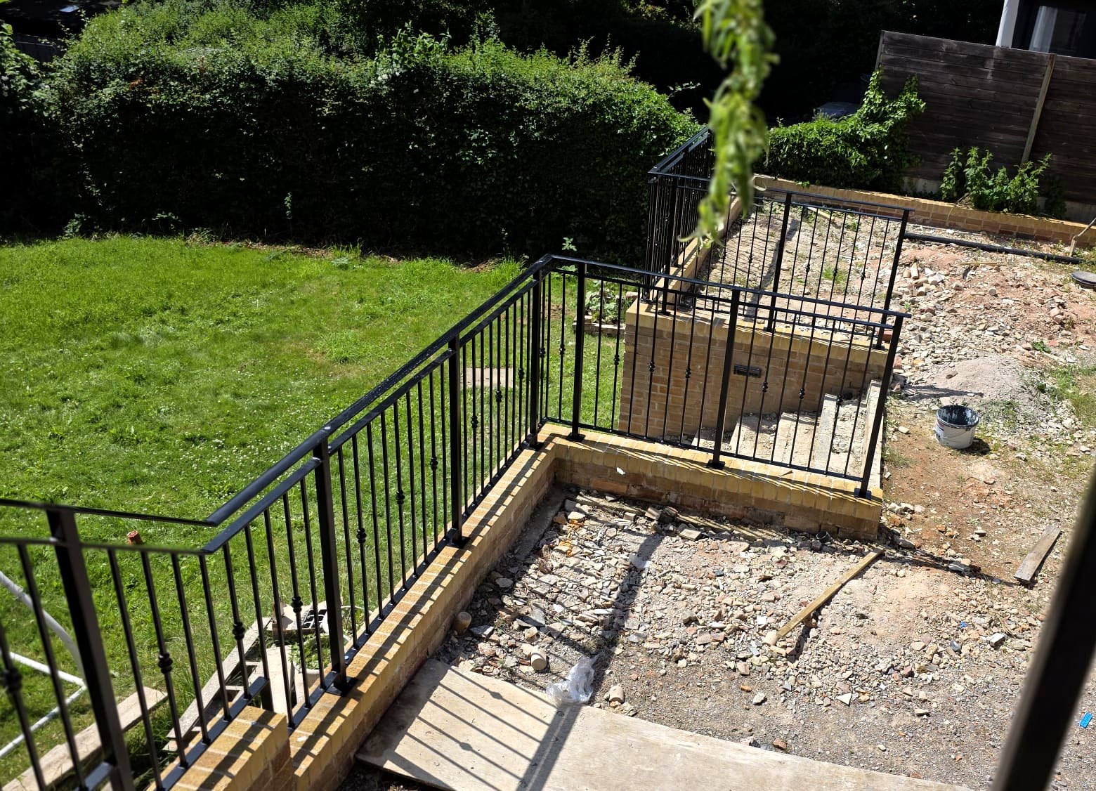 Black metal railings to a stepped garden terrace with steps down to the lawn, Sheffield