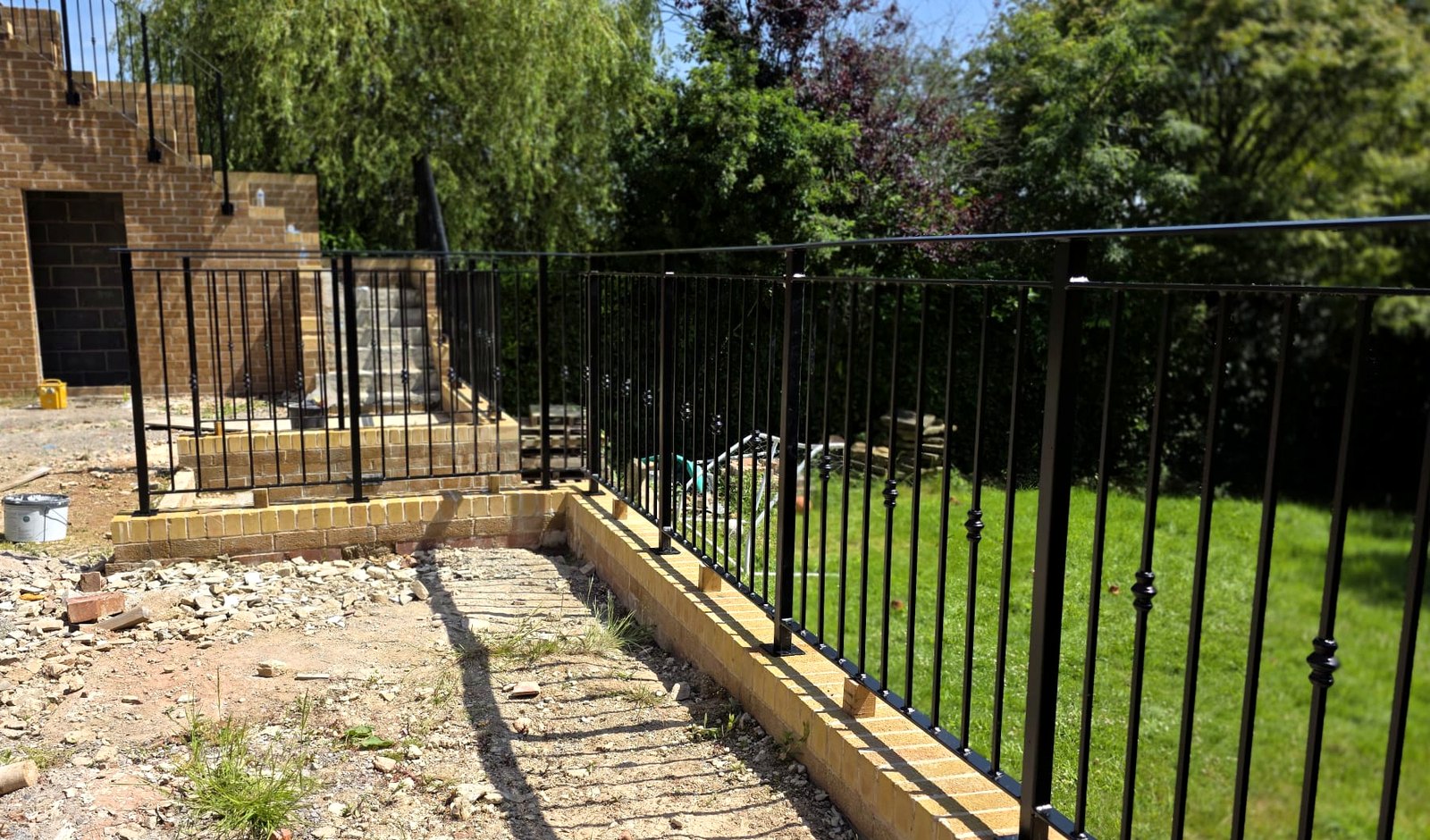 Black vertical bar-infill metal railings to a raised garden terrace edge, Sheffield