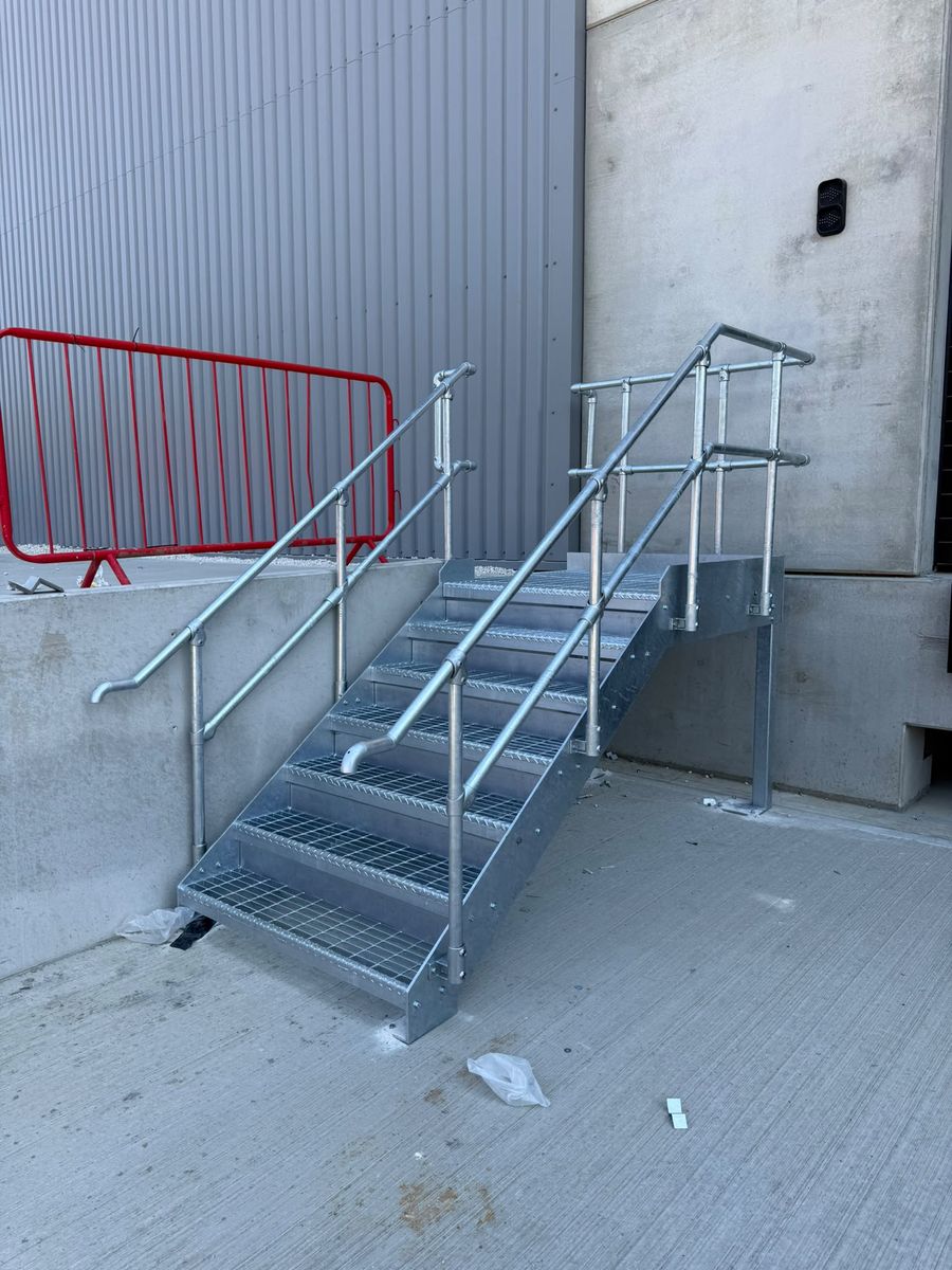Key clamp galvanised handrail and open mesh treads on industrial dock steps, Markham Vale