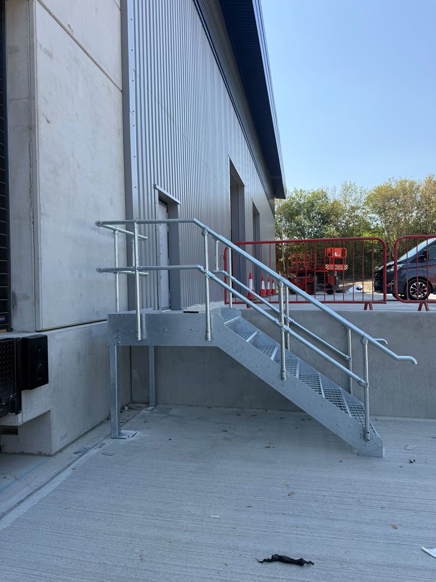 Galvanised access stair and landing carried on its own legs at an industrial loading dock, Markham Vale