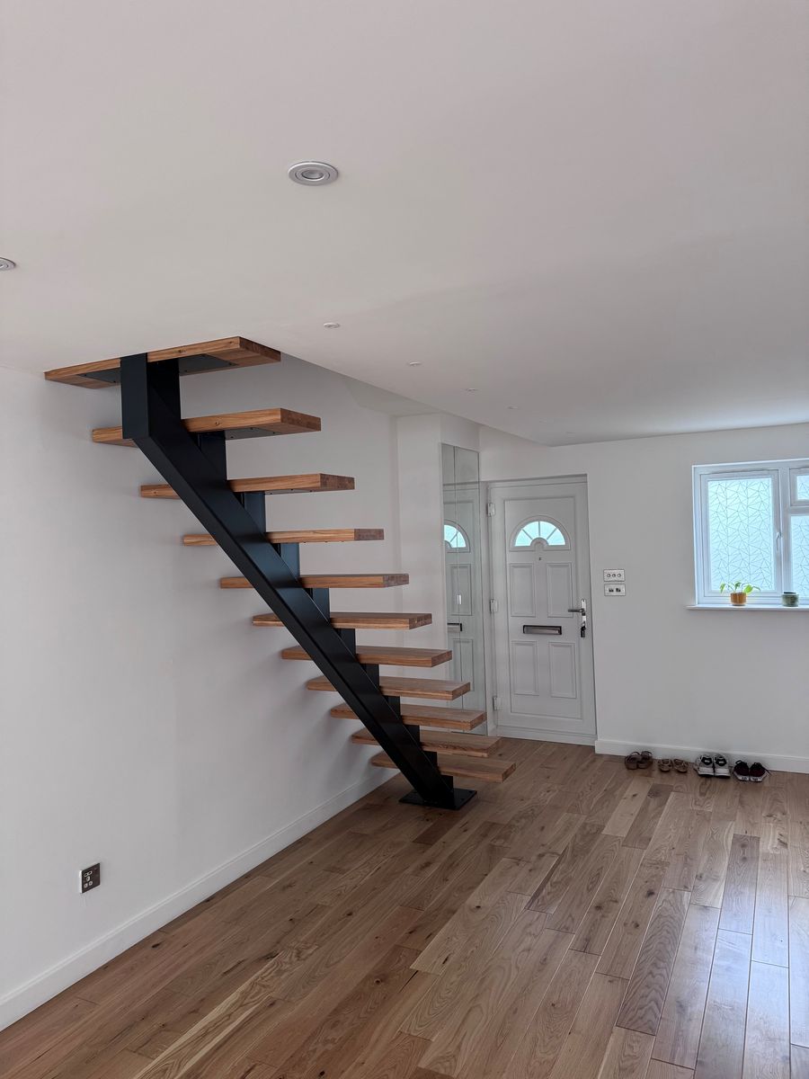 Black powder coated steel spine staircase with solid oak treads and open risers, Deptford London