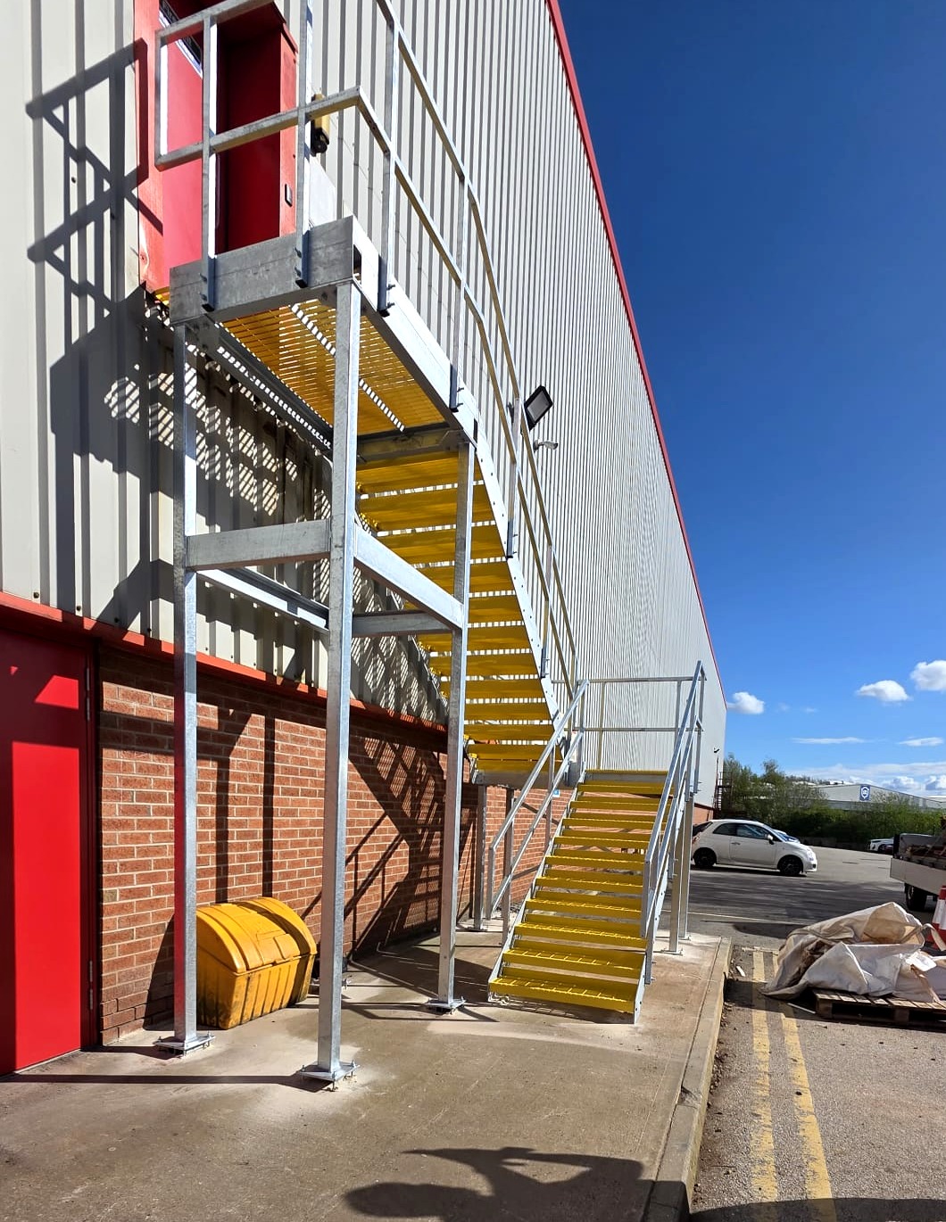 Side angle view of the galvanised staircase at Eurocell Alfreton showing underside of the yellow OMF top landing