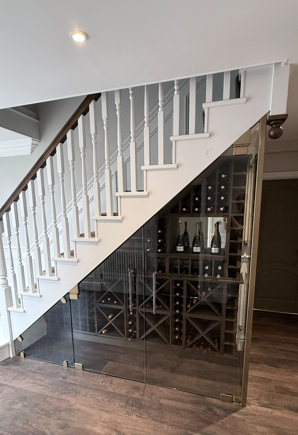 Under stairs glass wine store with doors cut to the rake of the staircase, Delamere Cheshire