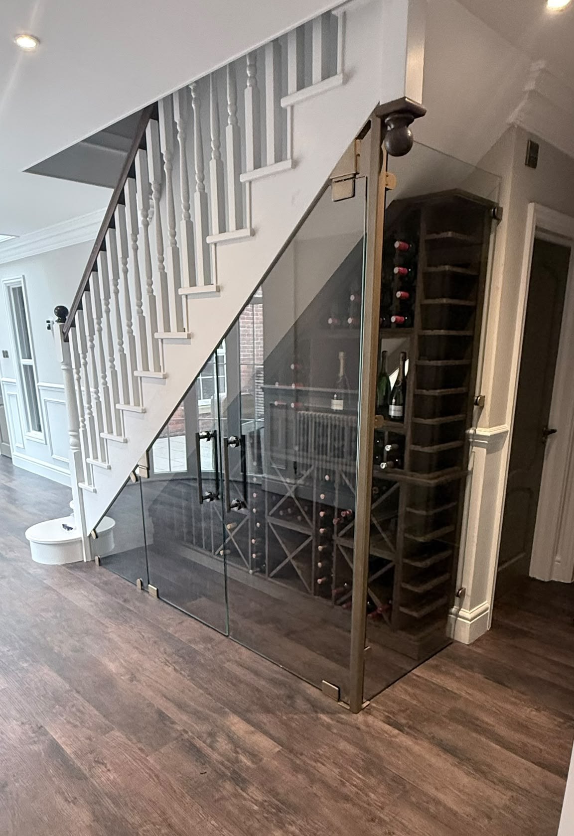 Glass under stairs wine store with a return panel to the side, Cheshire