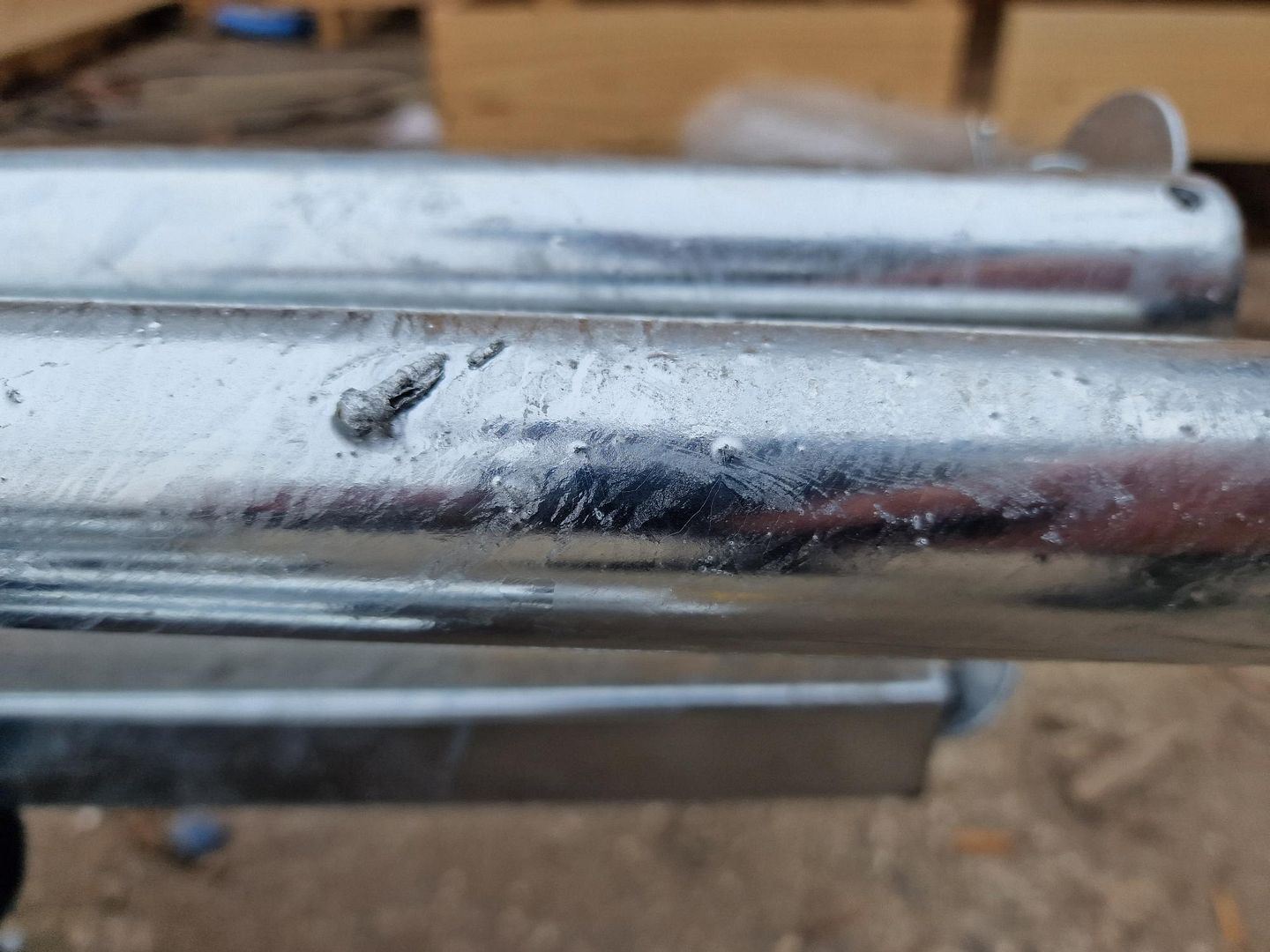 Zinc drips and pooling on a galvanized steel section after removal from the bath