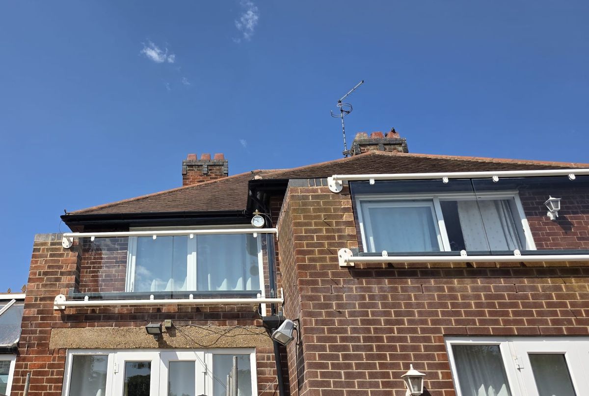 Two wide span glass Juliet balconies in RAL 9010 white guarding a flat roof terrace, West Bridgford Nottingham
