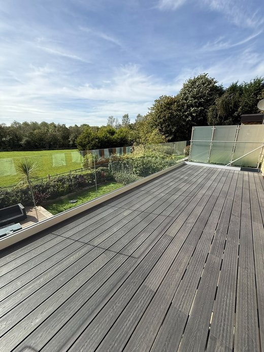 Frameless System 4 glass balustrade on a composite decked balcony looking out over the garden