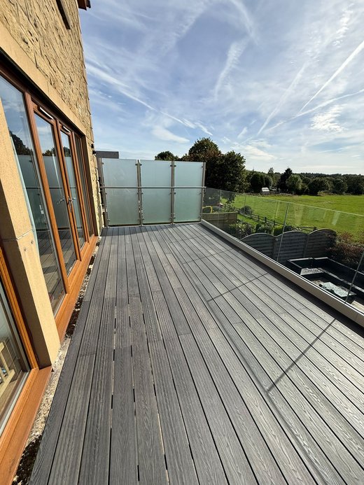 Composite decked walk-out balcony with frameless glass balustrade and frosted end screen
