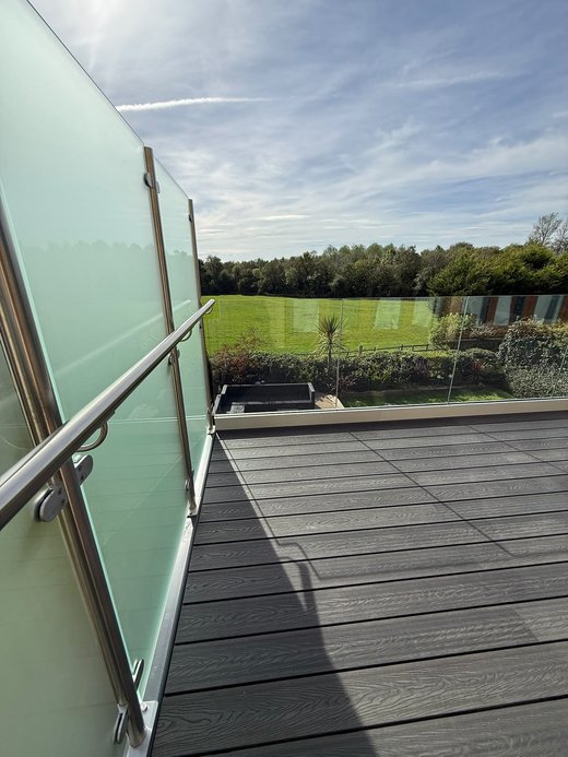 Frosted toughened glass privacy screen on stainless steel posts at the end of the balcony