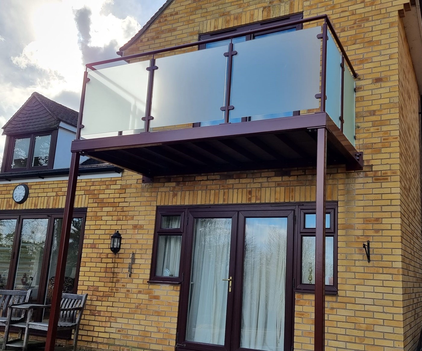 Brown powder coated walkout balcony colour matched to the uPVC windows and doors of a house in St Neots