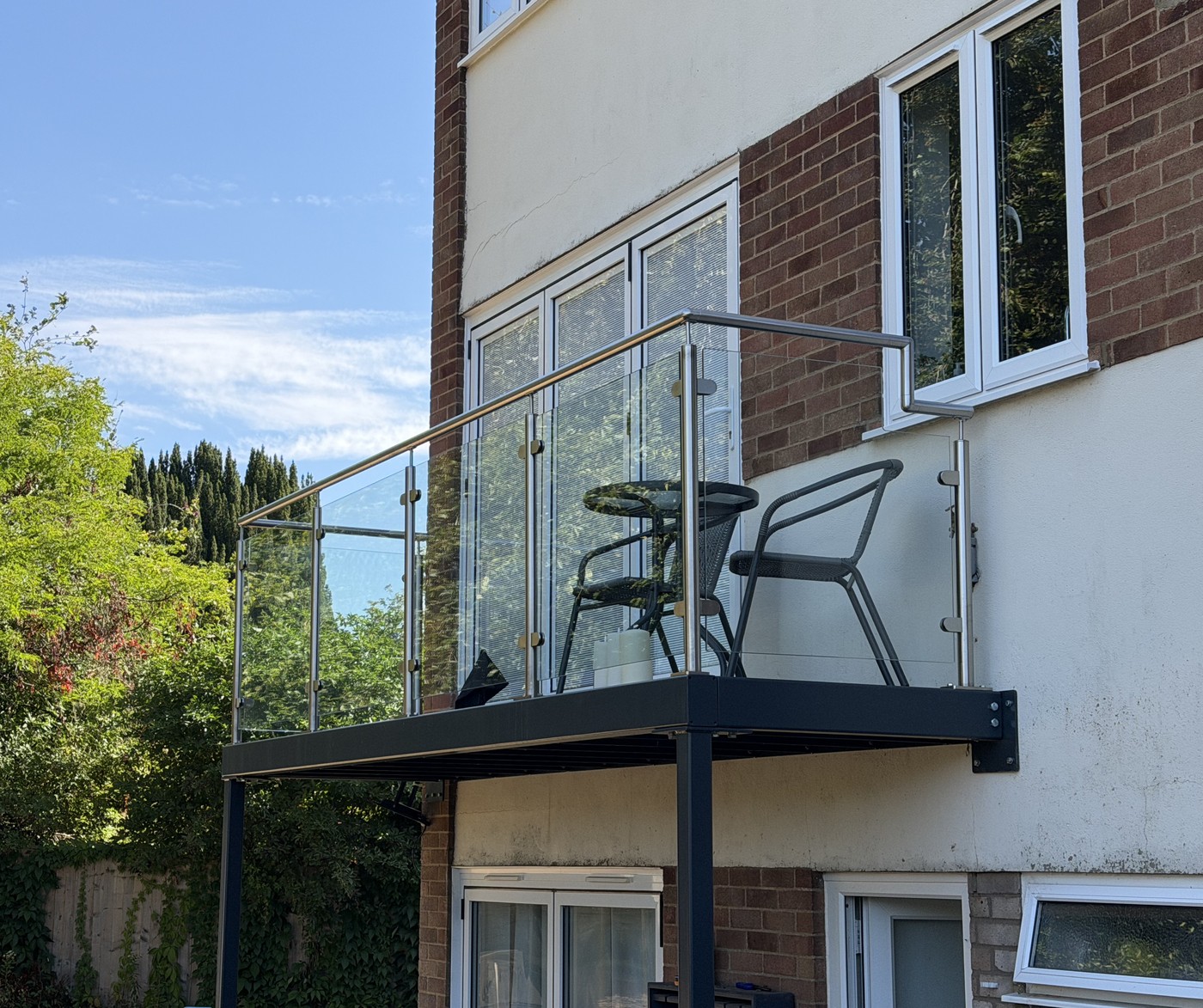 Post supported walk-out balcony with stainless steel and glass balustrade on a house in Great Missenden, Buckinghamshire